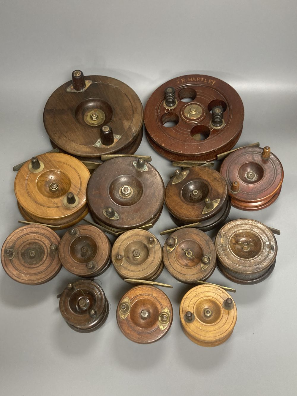 A collection of mahogany and brass fishing reels, largest 17.5cm (14)